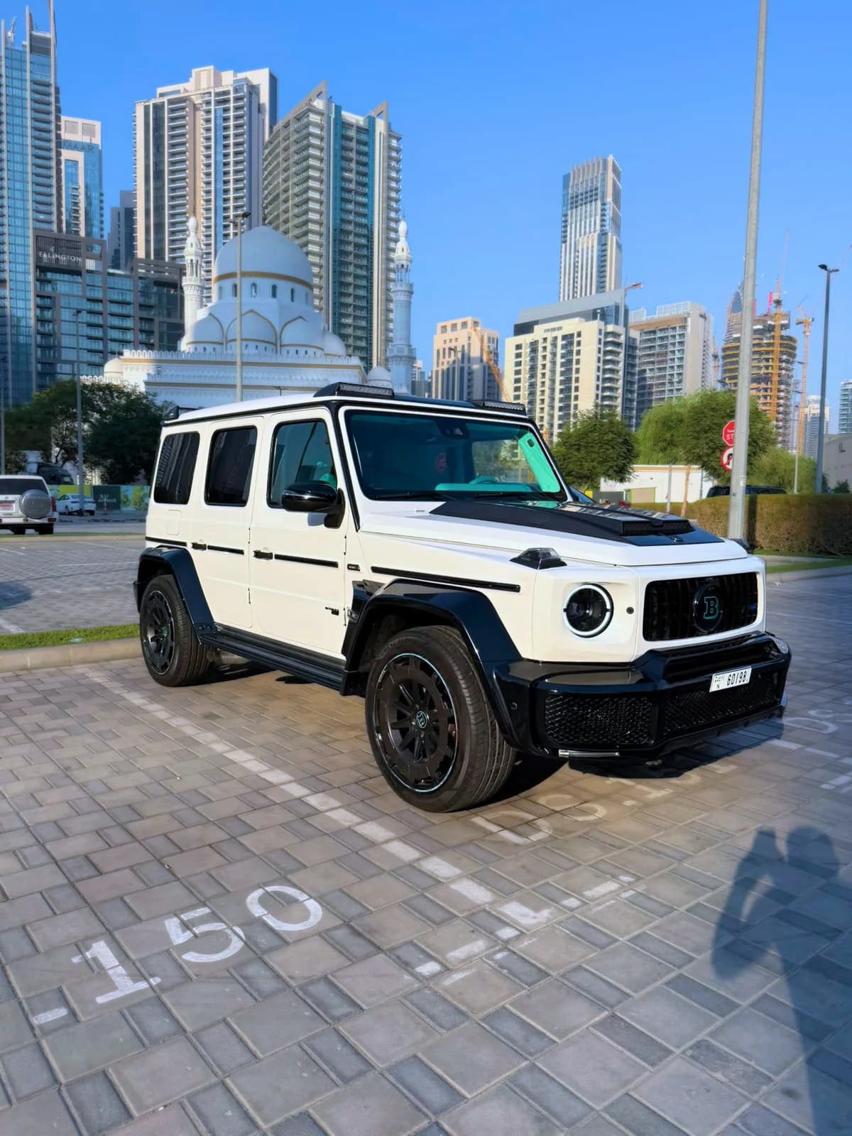 White Mercedes-Benz G-Class BRABUS 800 with a black wide-body kit photographed in Dubai